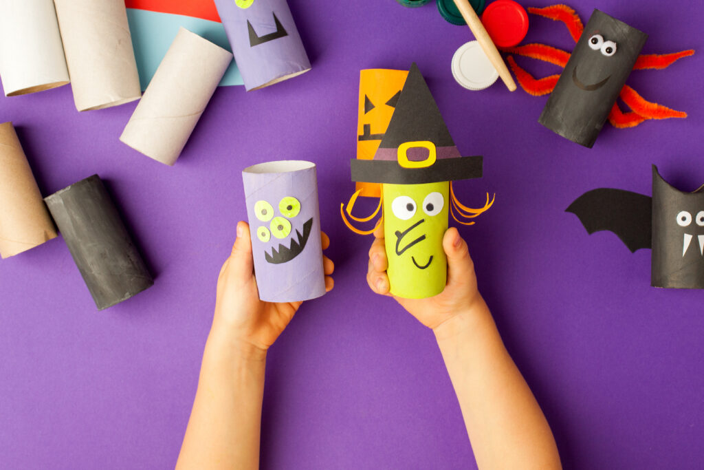 Decorazioni di Halloween con la carta. tubo della carta igienica a mano. Fai da te creativo per bambini sul tradizionale sfondo viola. Festa per il progetto di arredamento della casa. Ispirazione per l'artigianato di Halloween, concetto di riciclo